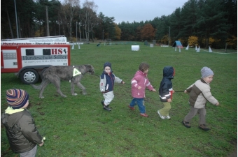 Die Kinder führen gemeinsam den grossen Hund.